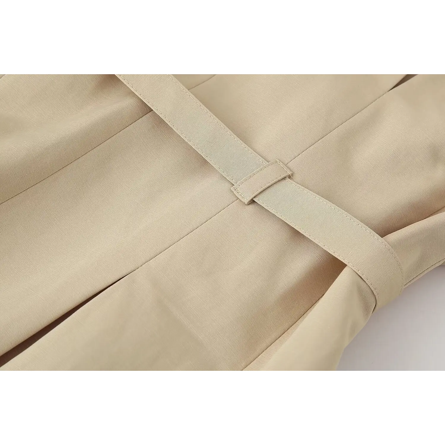 Close‑up view fabric belt loop and stitching detail of matching beige waist belt