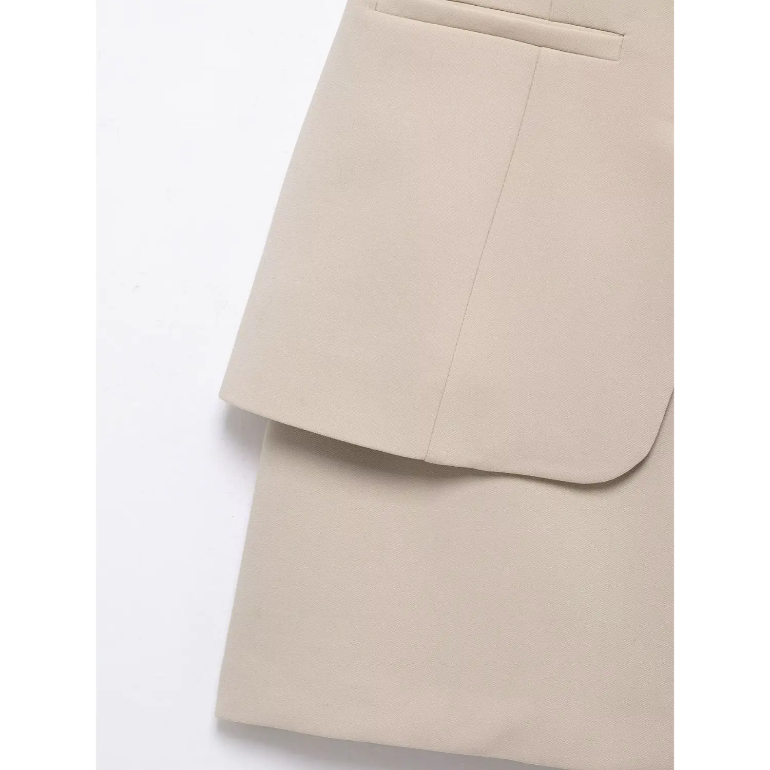 Macro shot of layered hem construction, separate blazer overlay panel above straight mini skirt, clean straight stitching, smooth matte suiting woven fabric