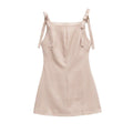 Full back flat view of a beige gingham mini dress with bow straps, center back zipper, and A-line silhouette.