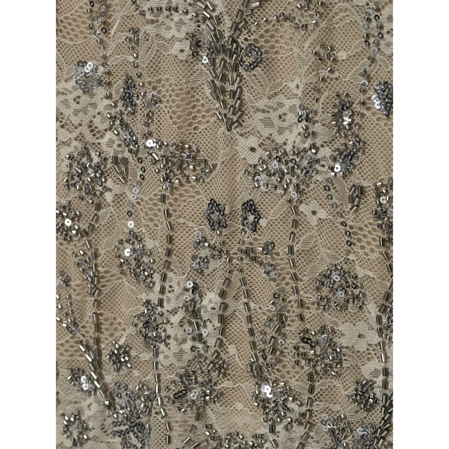 Macro close‑up of floral tube bead and sequin embroidery on sheer beige lace halter top fabric