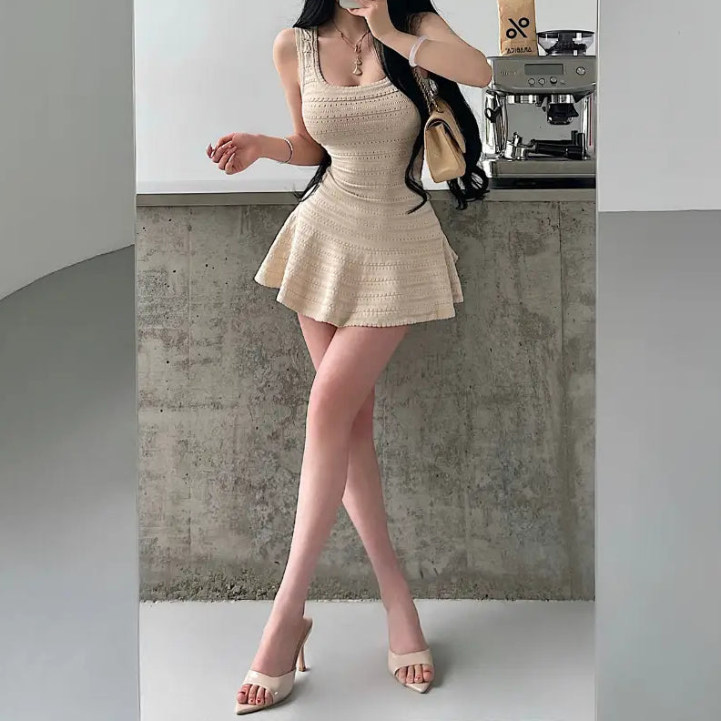 A woman taking a mirror selfie in a beige knit mini dress with a square neckline, textured pattern, and flared skirt.