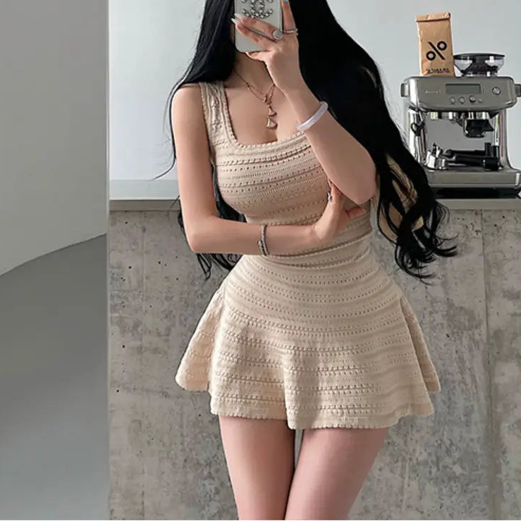 A woman wearing a beige knit mini dress with a square neckline, textured pattern, and flared skirt, styled with accessories.