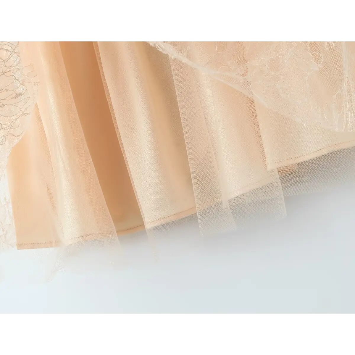 Close-up of the layered tulle skirt hem and inner lining on the beige lace dress