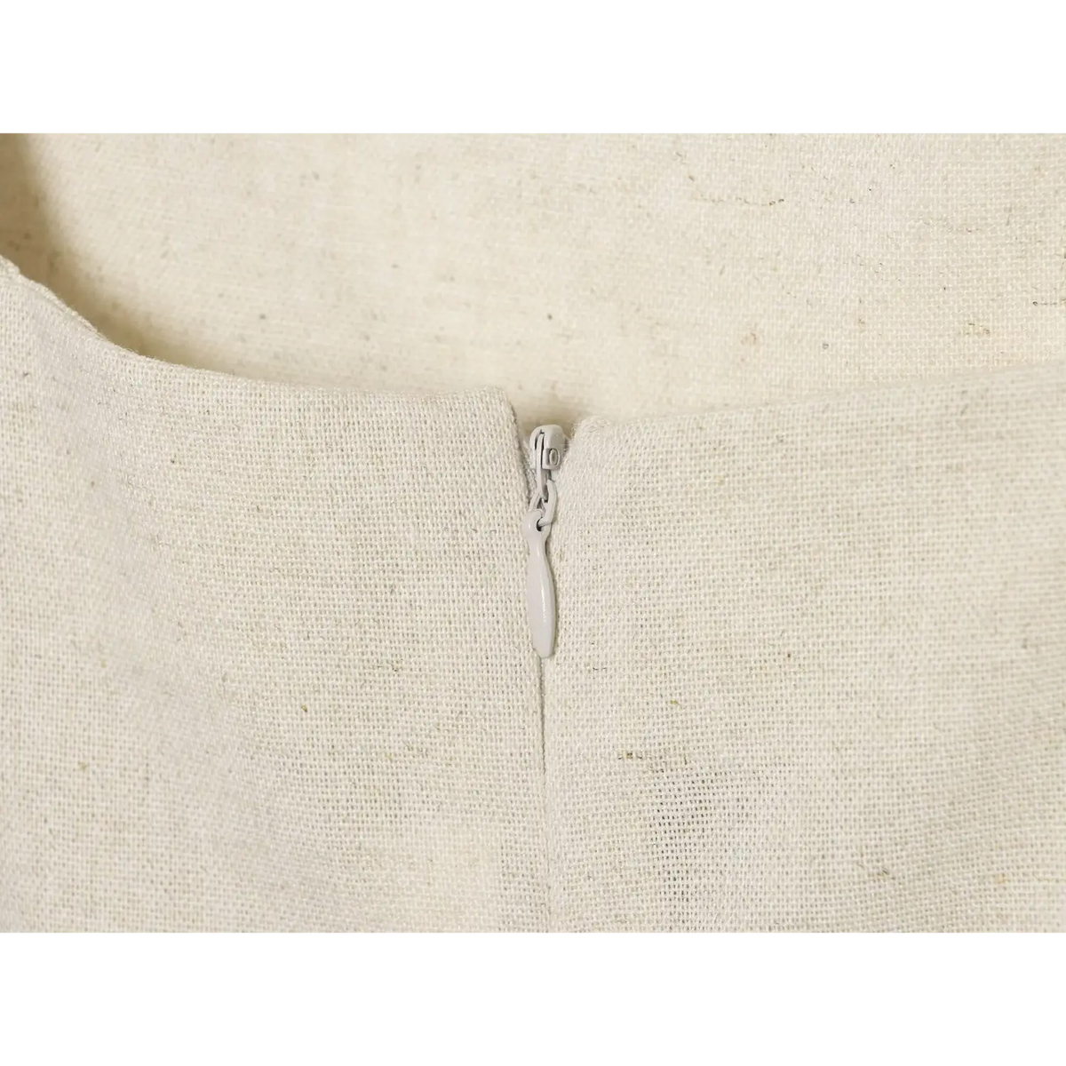 Close-up of back zipper on beige linen dress