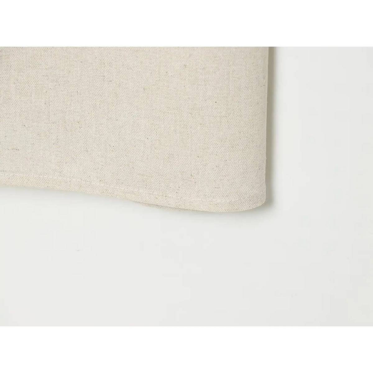 Close-up of finished hem on beige linen dress