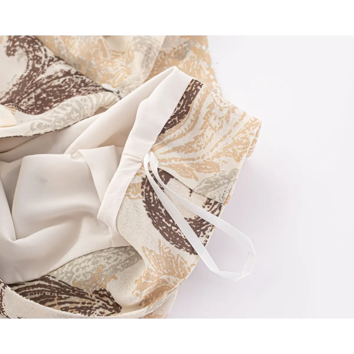 Close-up of the inner lining and adjustable strap detail on the beige skirt.