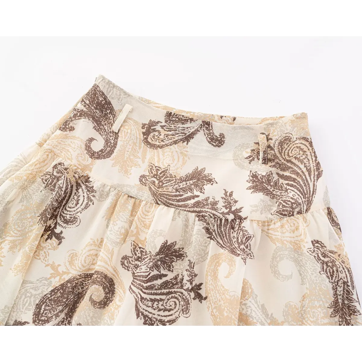 Close-up of the waistband, belt loops, and paisley print on the beige skirt.