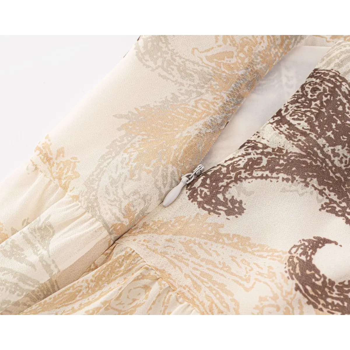 Close-up of the side zipper and paisley print on the beige skirt.