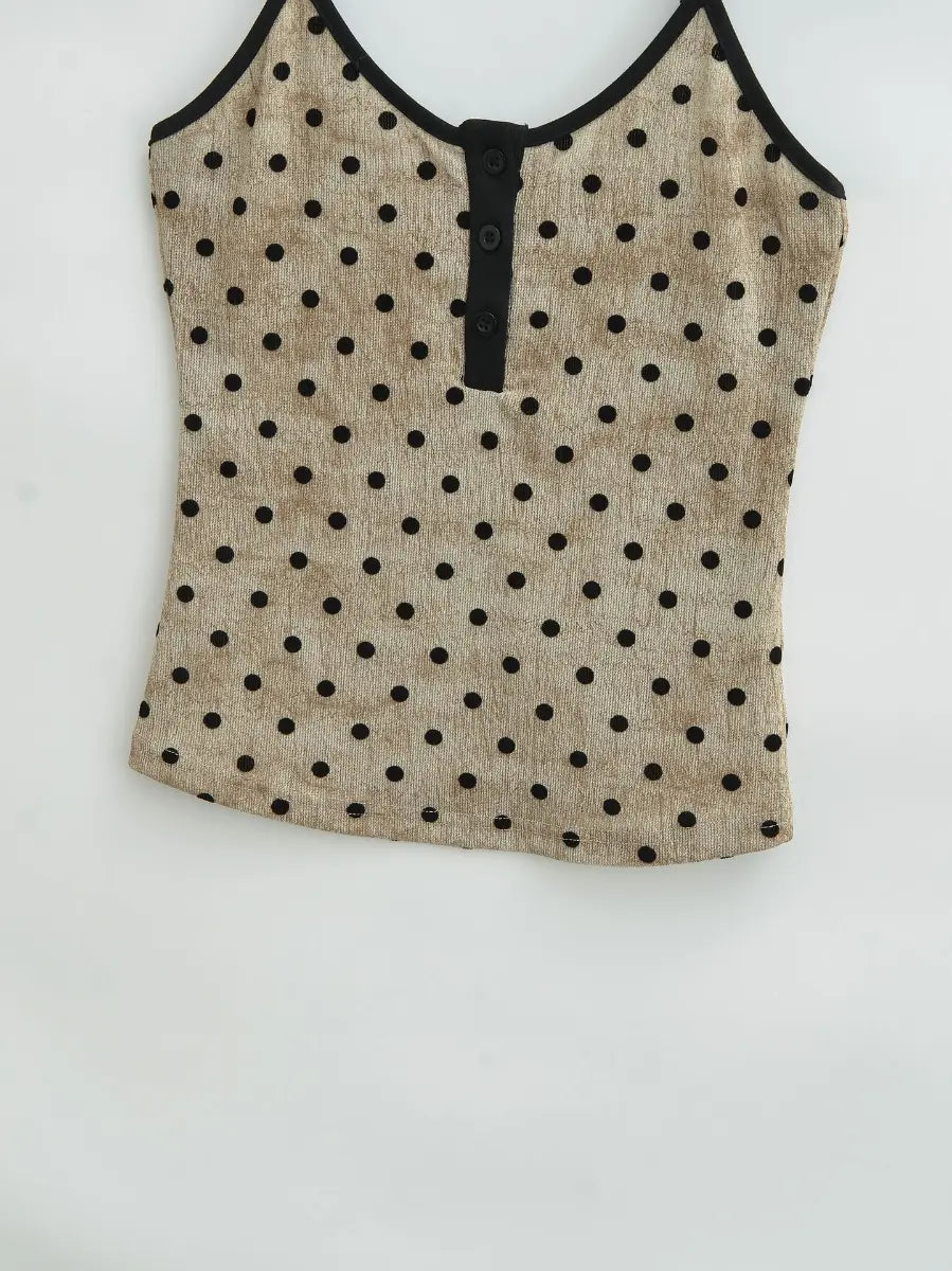 Close-up of the full front silhouette and hemline of the beige polka dot cami top