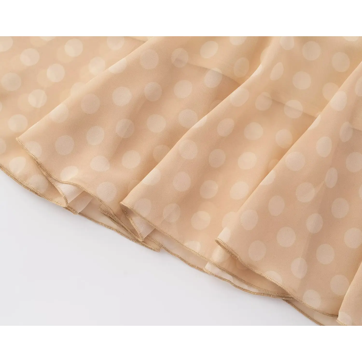 Close‑up of flowy mermaid ruffle hem and fine overlock edge on chiffon polka dot midi dress