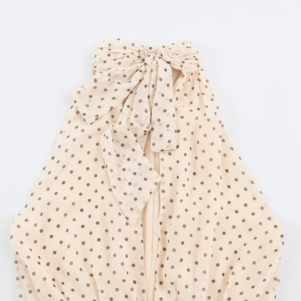 Full view of back neck bow tie detail on beige polka dot halter maxi dress