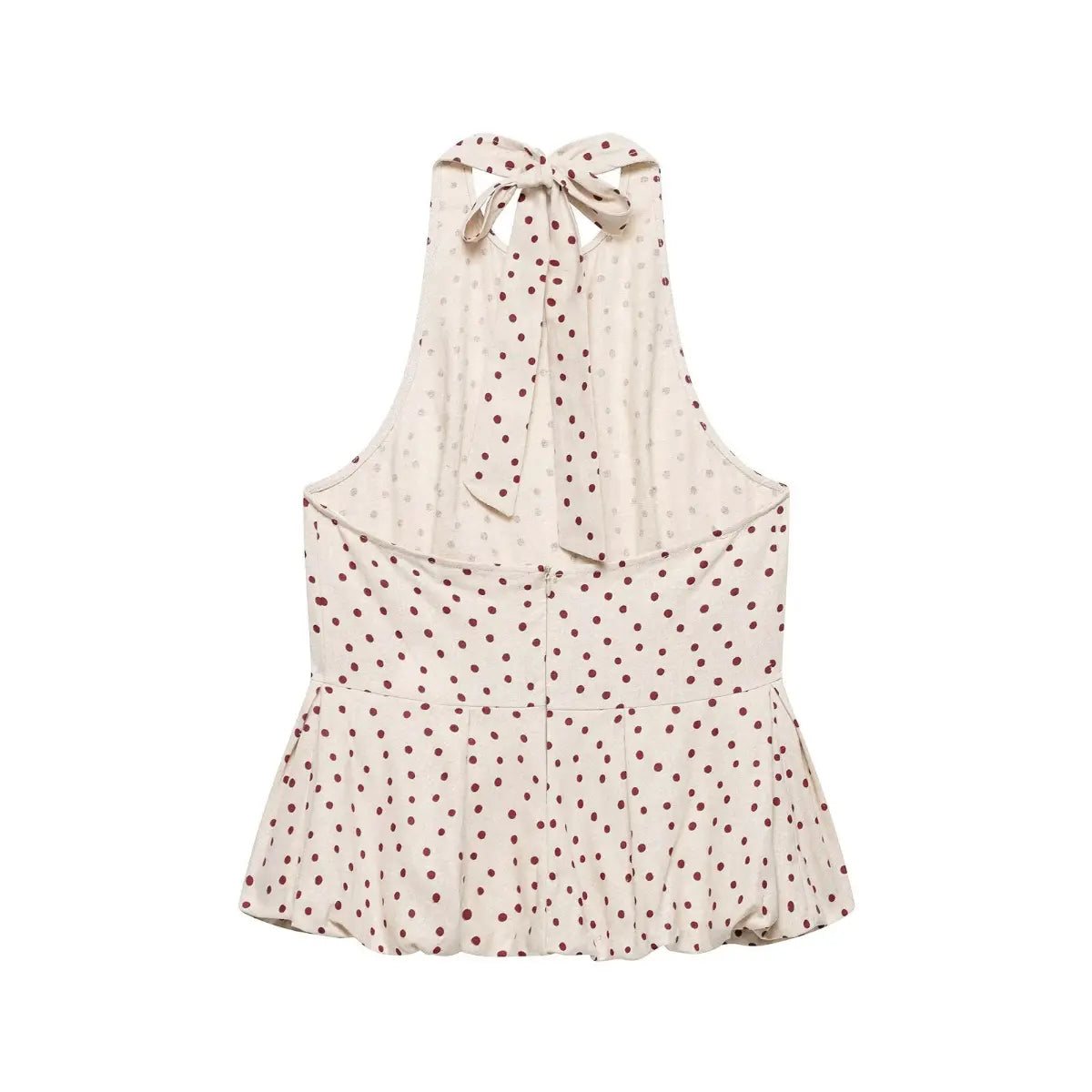 Back flat view of a beige halter peplum top with red polka dots, displaying the tie closure, zipper, and full silhouette.