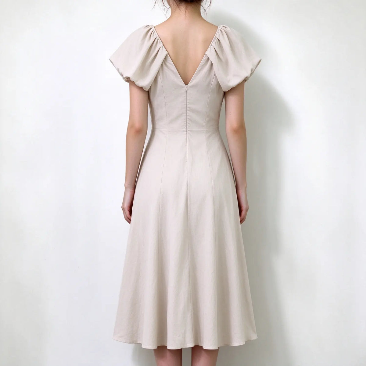 Model back view, beige puff sleeve v back maxi dress, invisible center back zipper, flared flowy linen maxi skirt