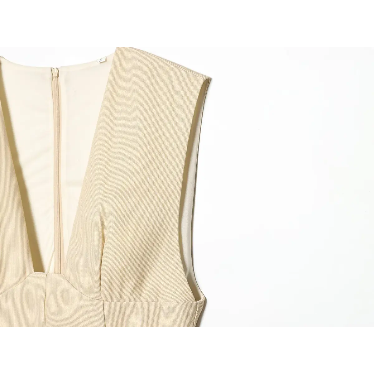 Shoulder and back zipper detail of the beige fine-striped dress