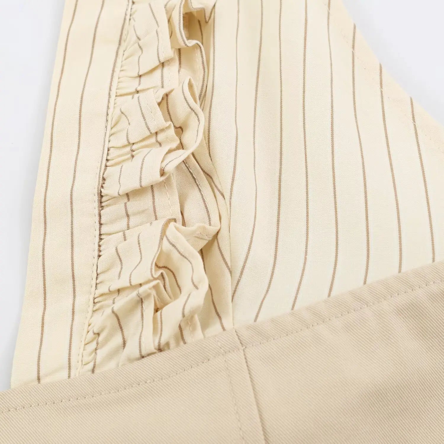Close-up view of frill ruffle stitching on beige striped halter dress bodice