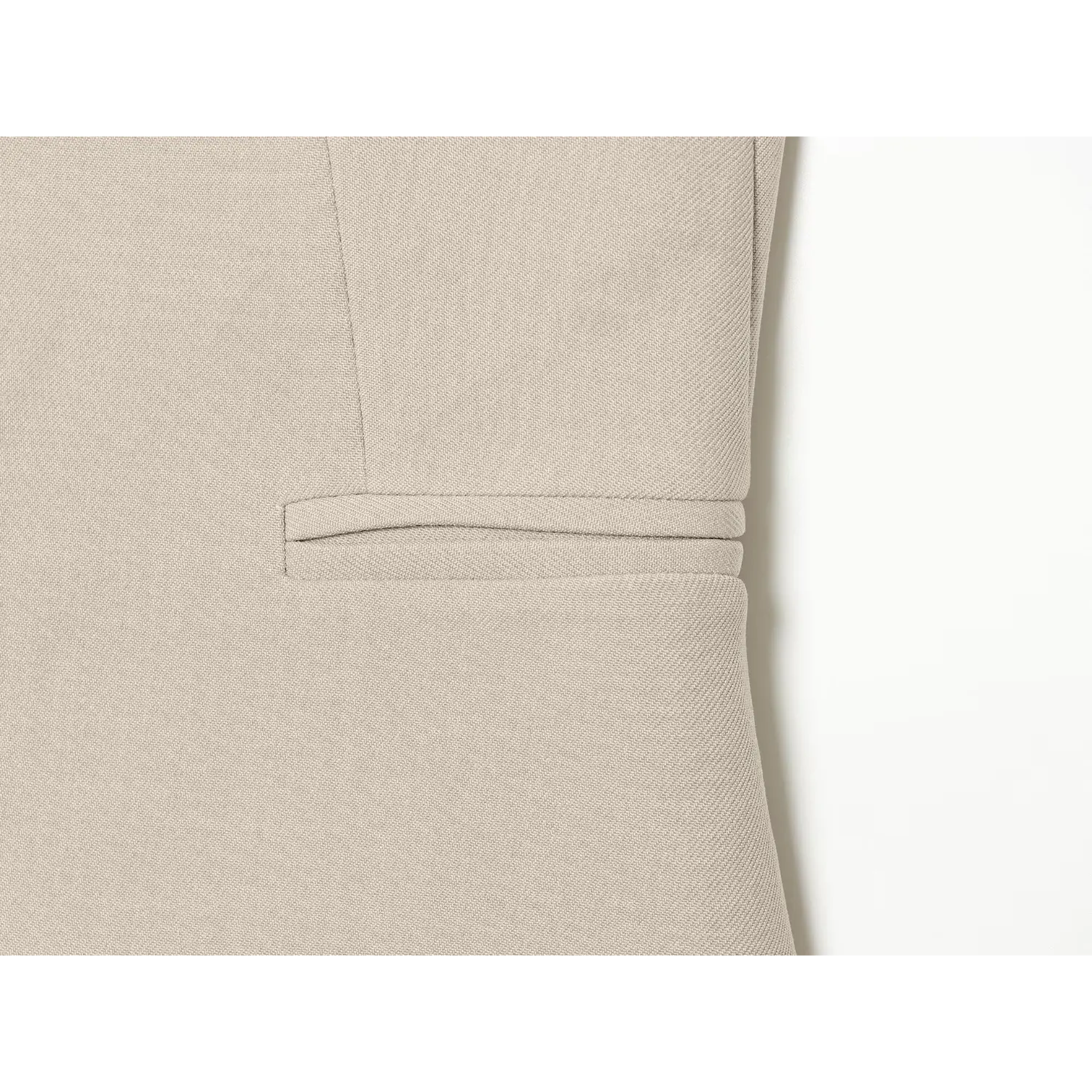 Close‑up view of front slip pocket detail on beige tailored suit vest