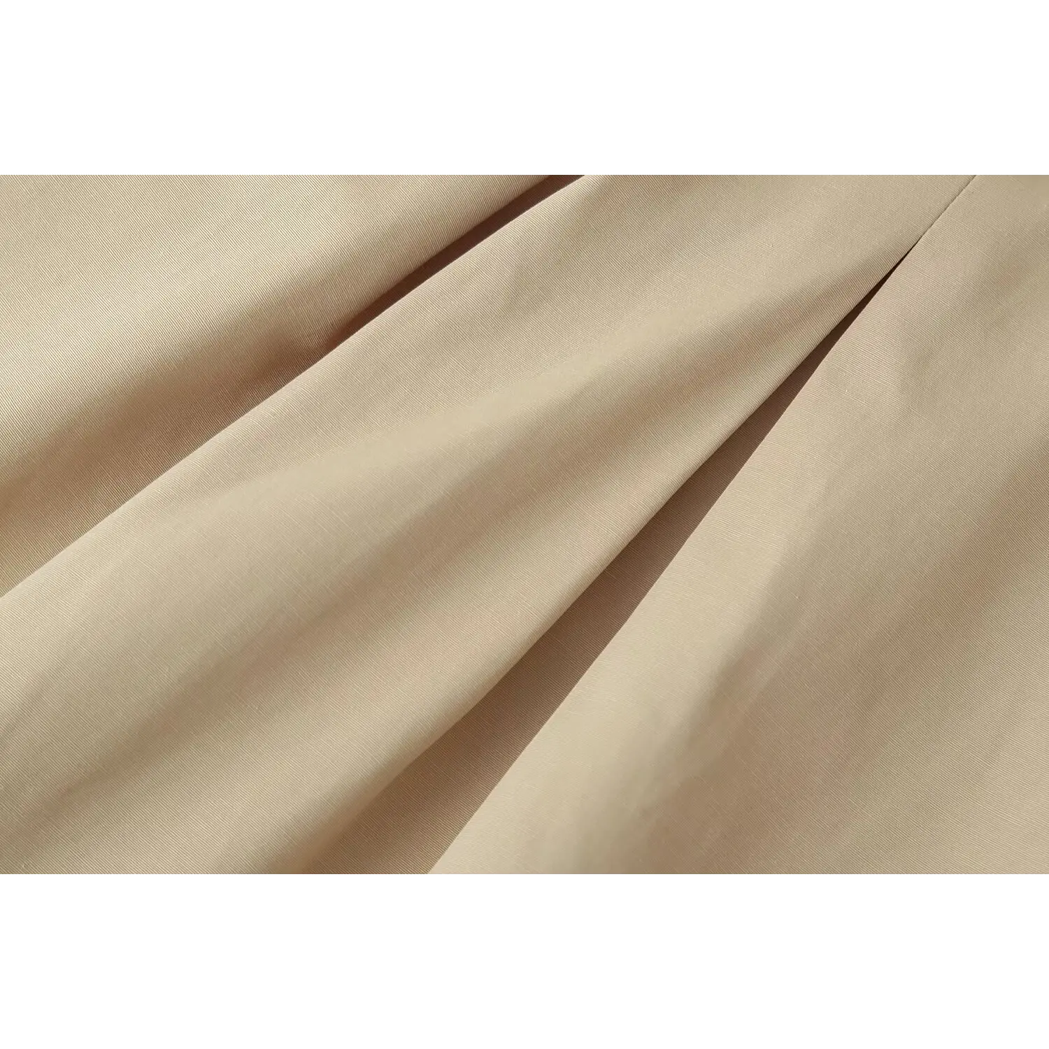 Soft woven fabric texture close‑up of beige structured mini dress, natural fabric drape