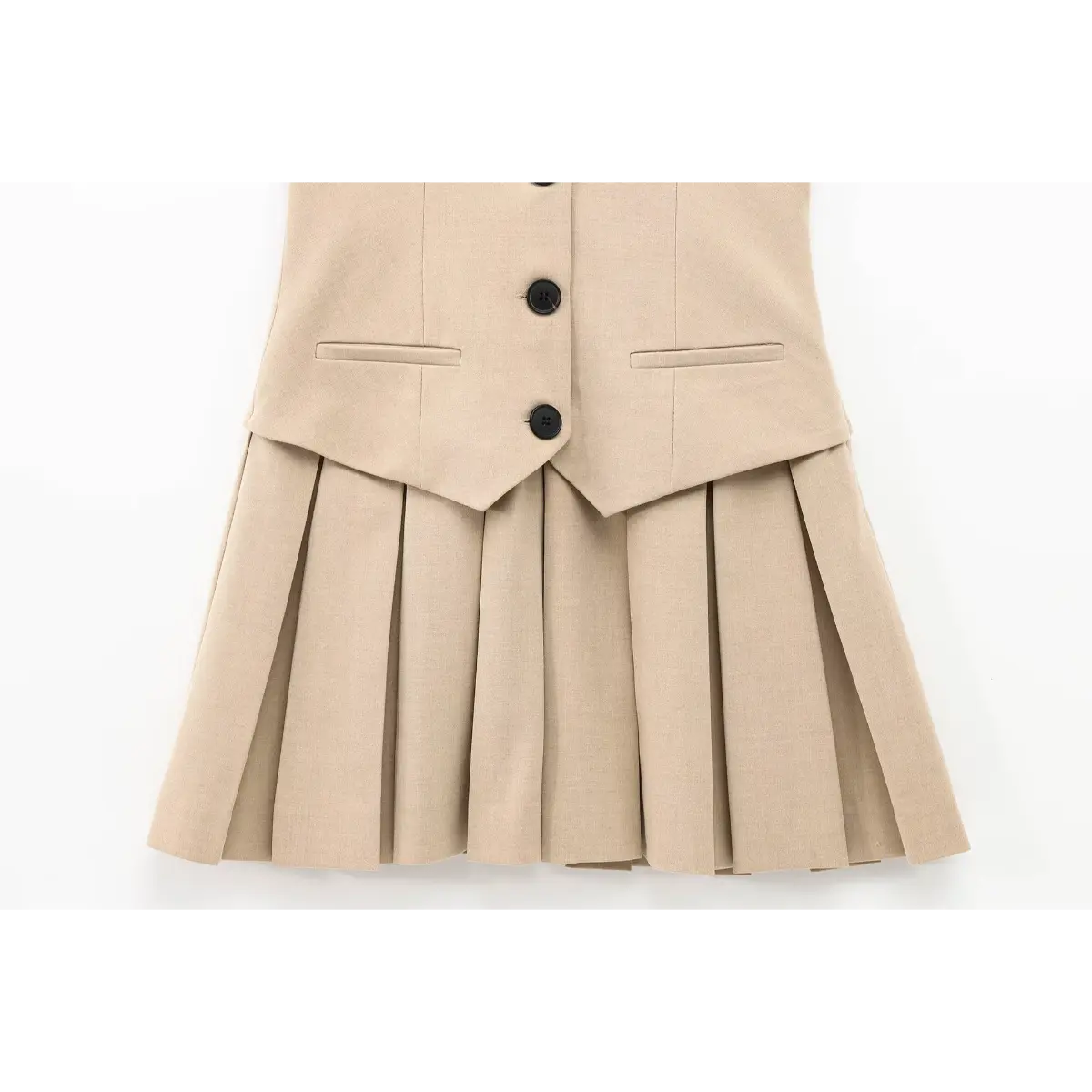 Close-up of the sharp, uniform pleats on the skirt hem of the beige tailored vest mini dress.