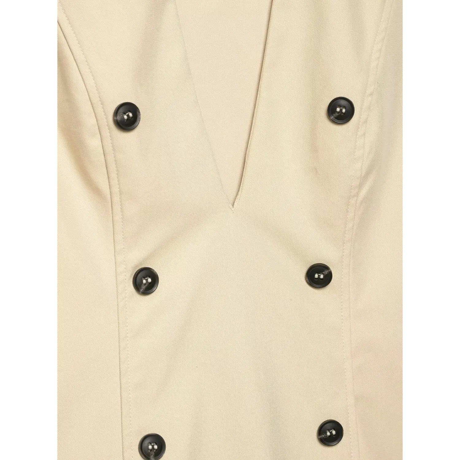 Macro close‑up of double‑breasted black buttons and twill fabric texture on beige sleeveless trench dress