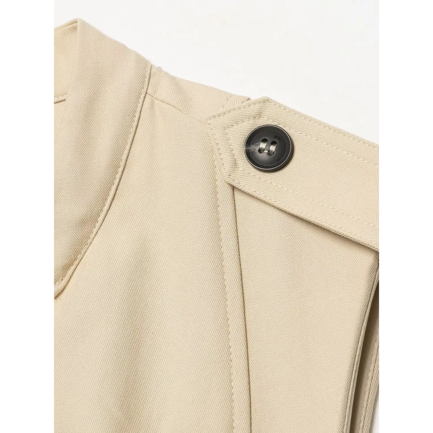 Macro close‑up of shoulder epaulet black button, twill fabric and fine stitching detail