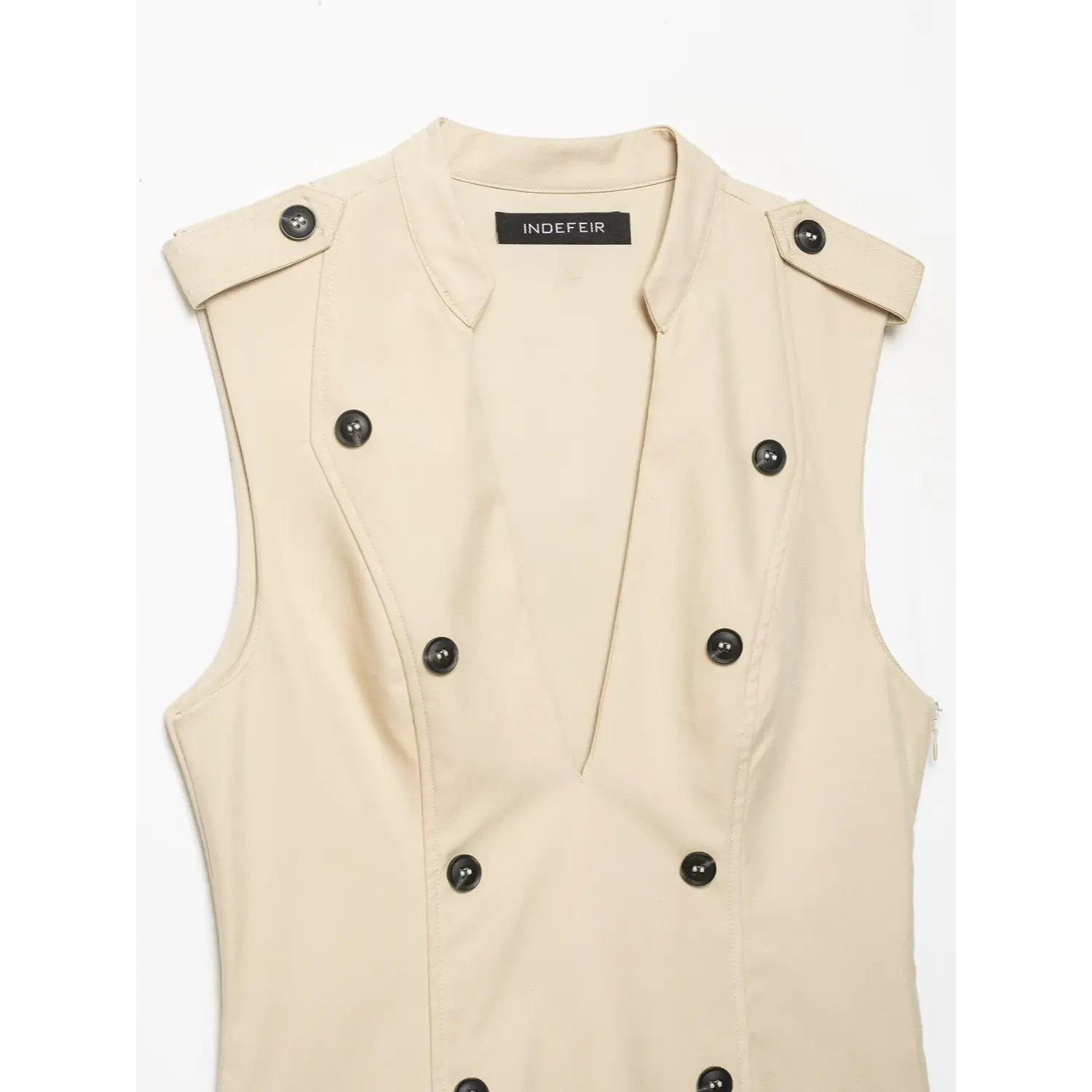Close‑up view of stand collar, deep v neckline and double‑breasted buttons on beige sleeveless trench dress