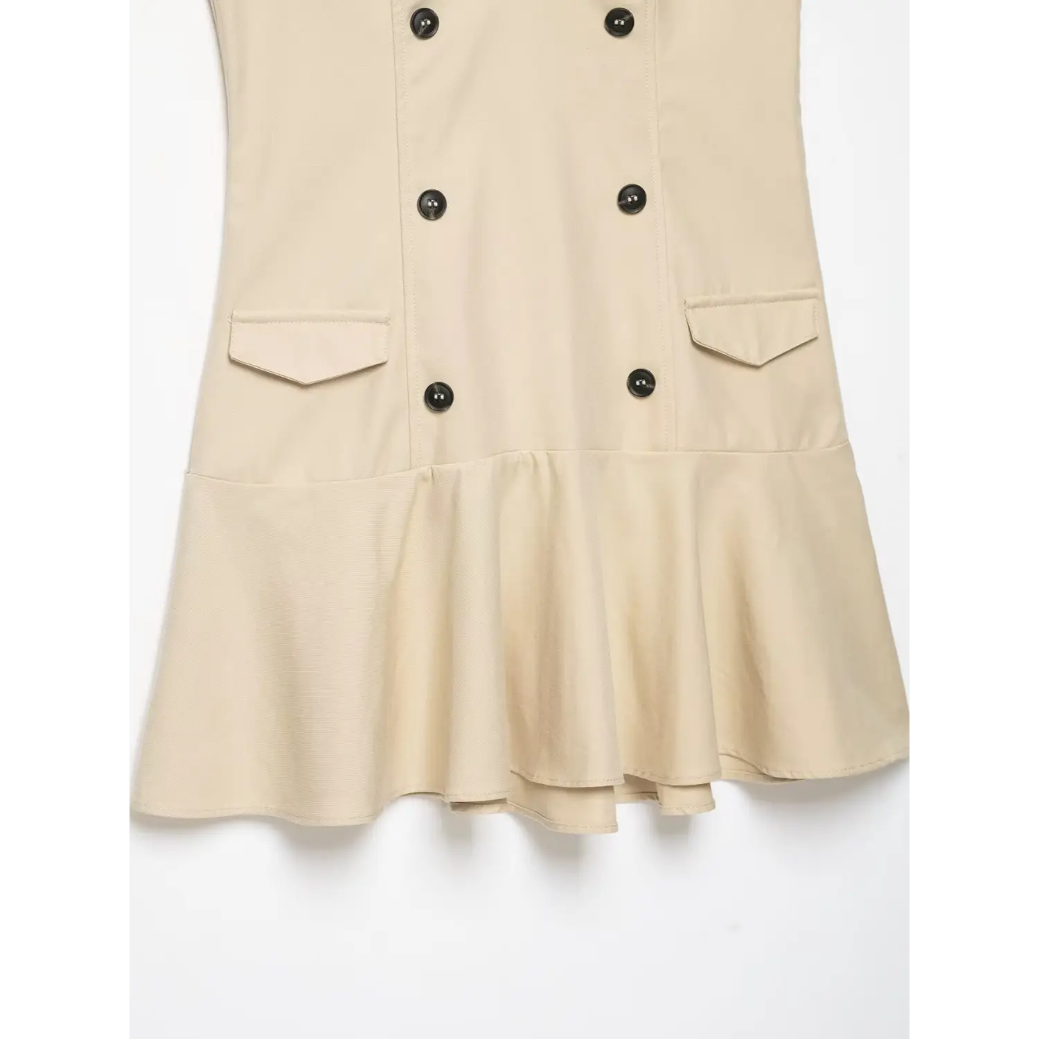 Detail shot of front patch pockets and flared ruffle hem on beige sleeveless trench mini dress