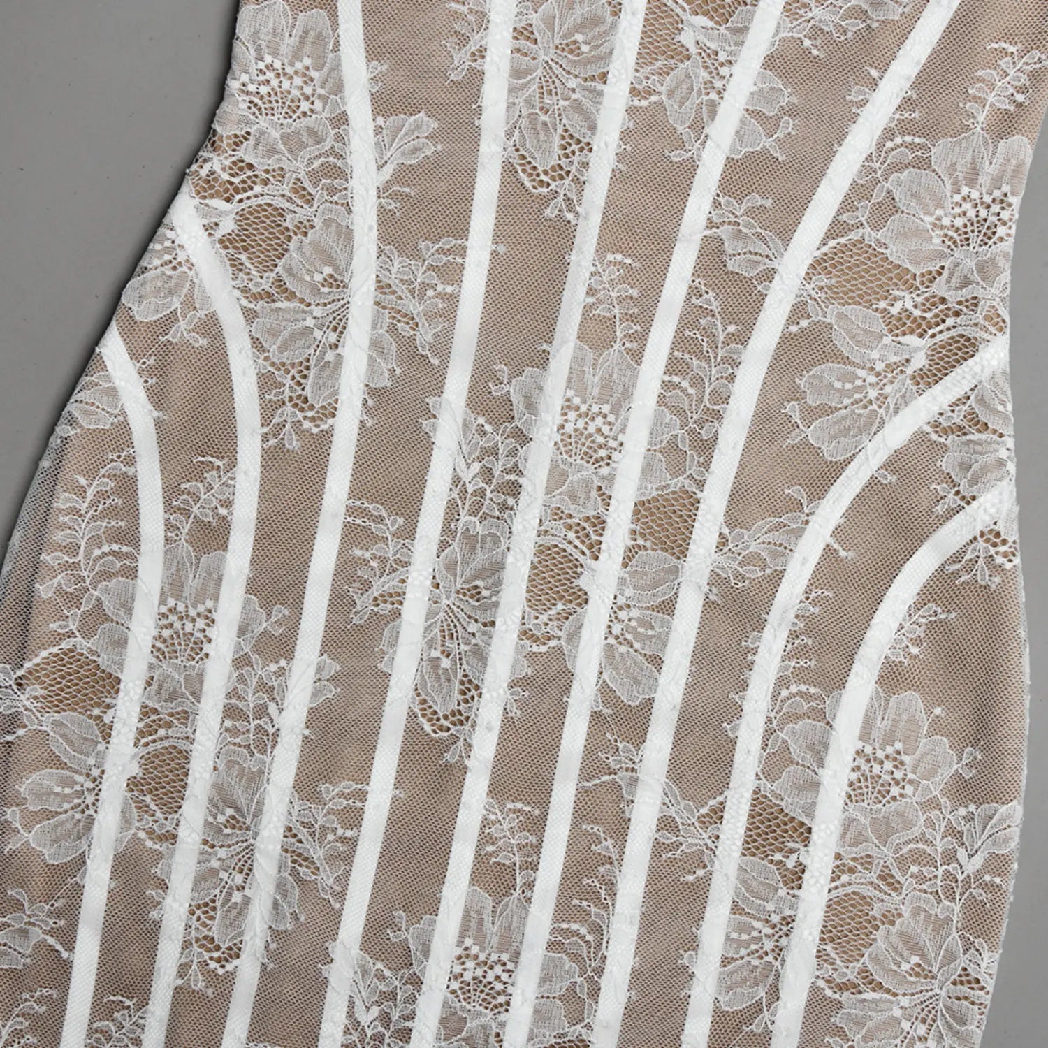 Macro close‑up vertical boning stripe construction over white floral lace beige mesh base