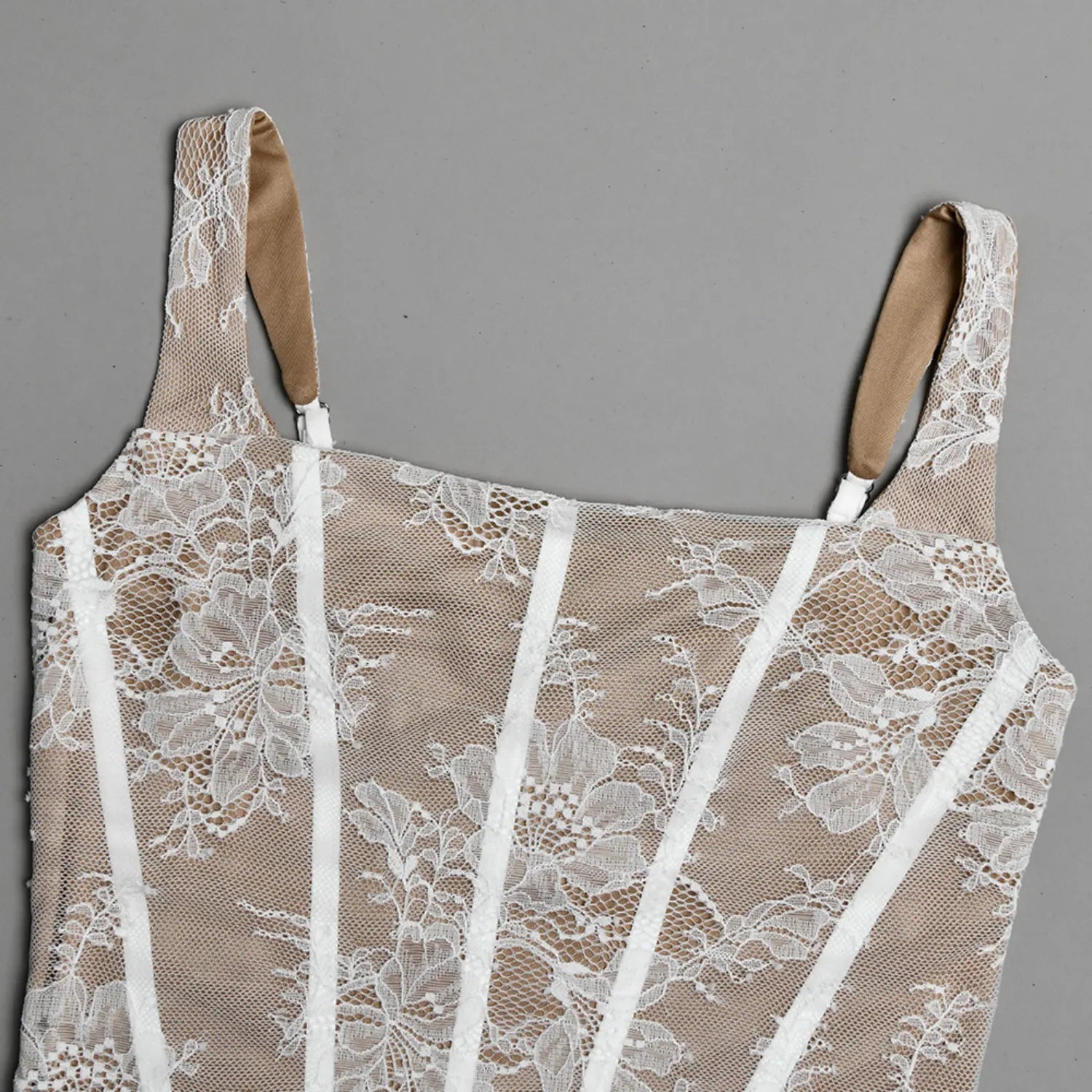 Flat close‑up front bodice adjustable strap and vertical boning white floral lace over beige lining
