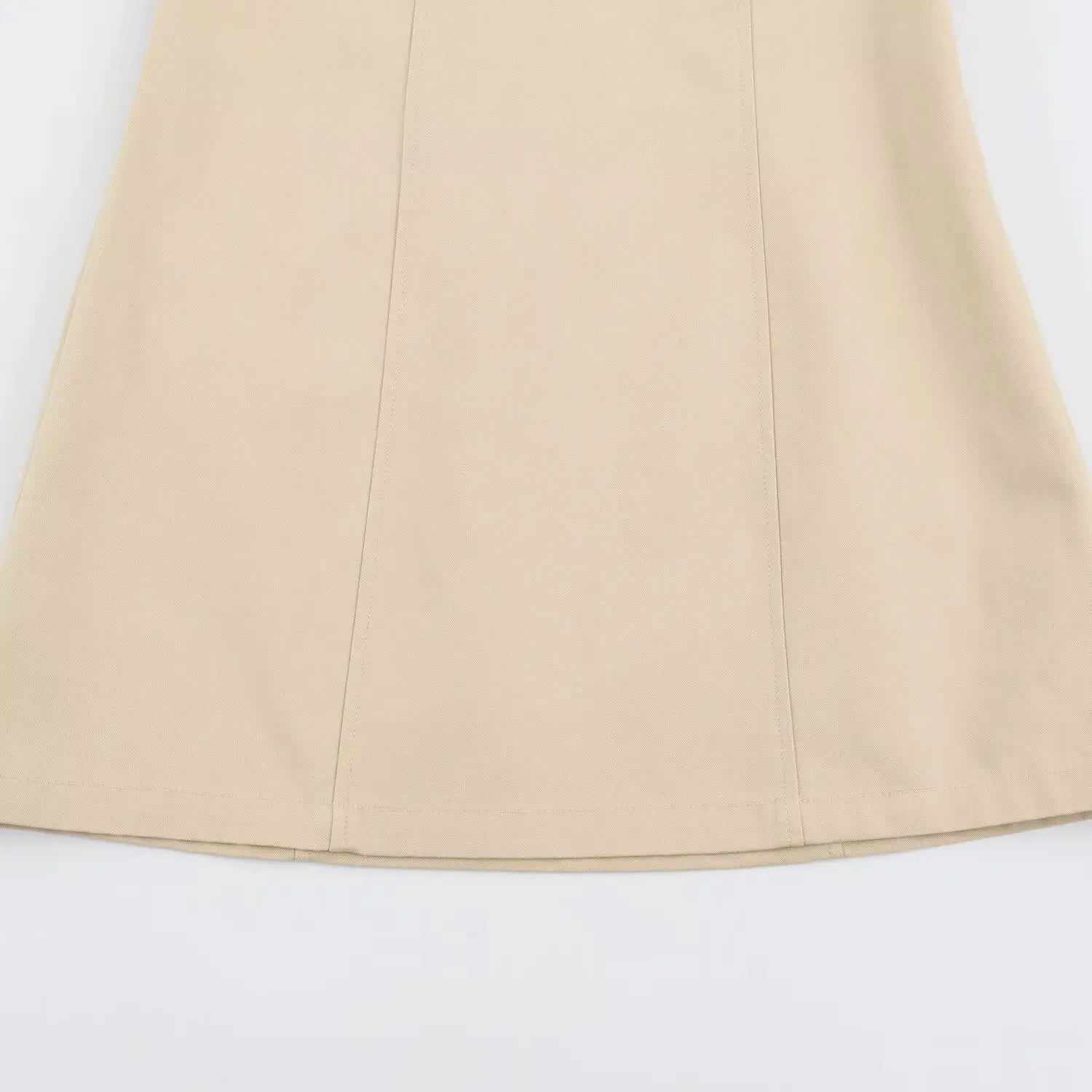 Flat view of structured panel skirt on solid beige woven mini dress, white background