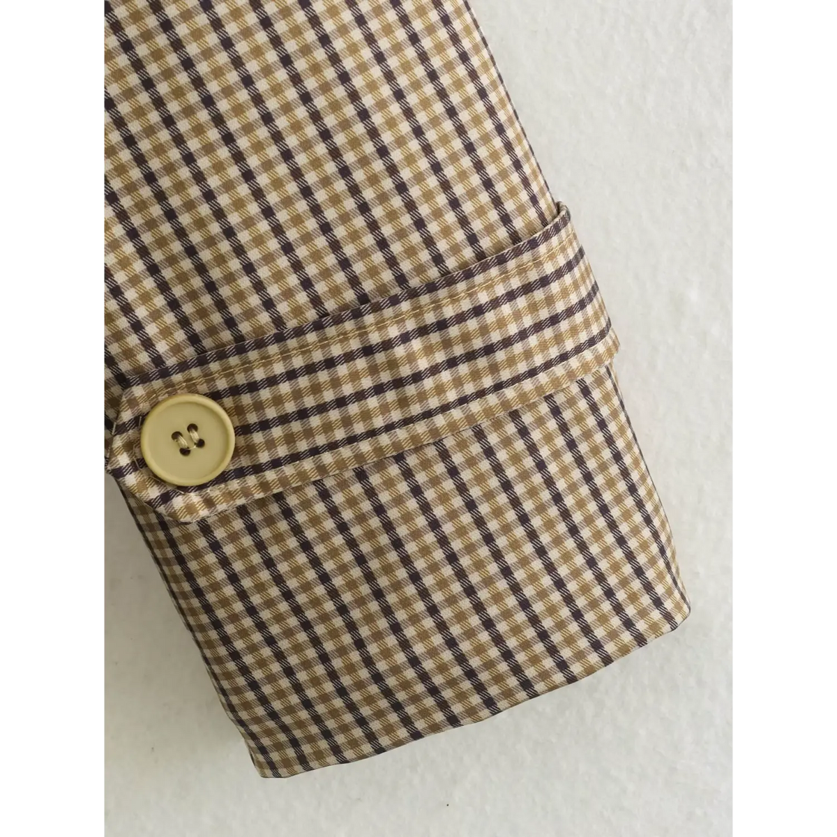 Close-up of gingham cuff strap and button