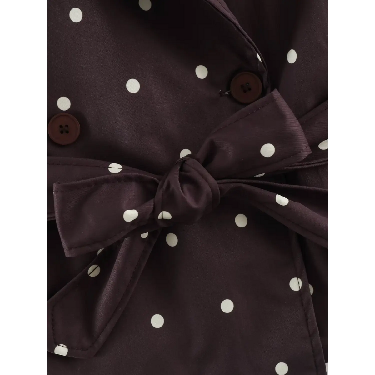 Close-up of polka dot belt bow and buttons