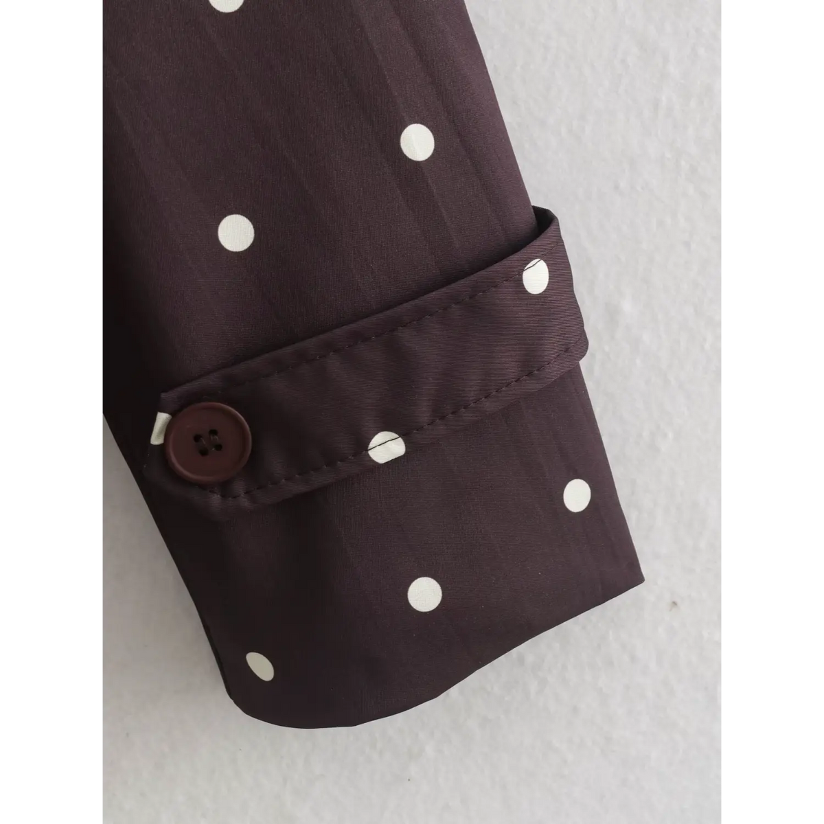 Close-up of polka dot cuff strap and button