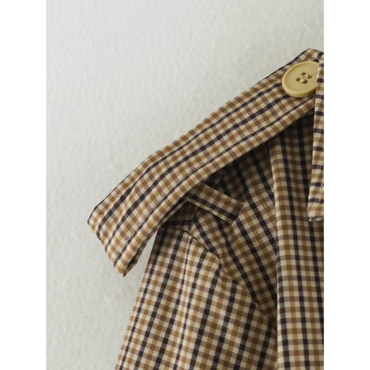 Close-up of gingham shoulder epaulette and button