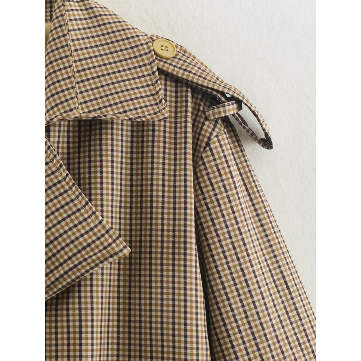 Close-up of gingham shoulder epaulette and strap