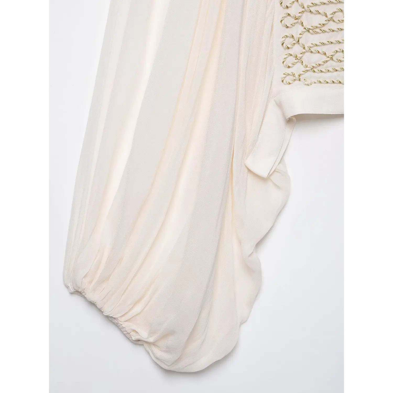 Close‑up view of voluminous bishop puff sleeve, lightweight flowy white fabric, elastic cuff detail
