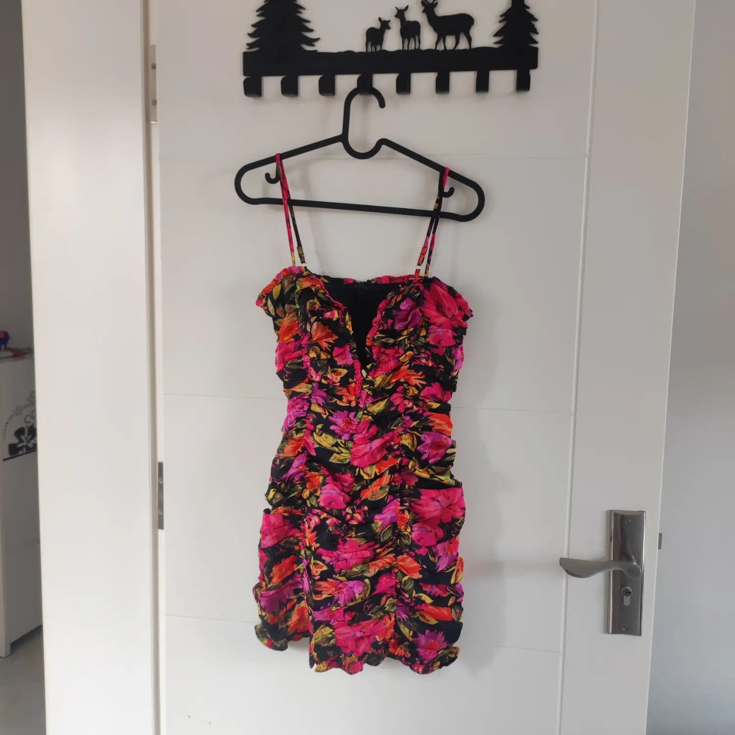 Hanging front view black base vibrant pink orange floral print ruched cami mini dress