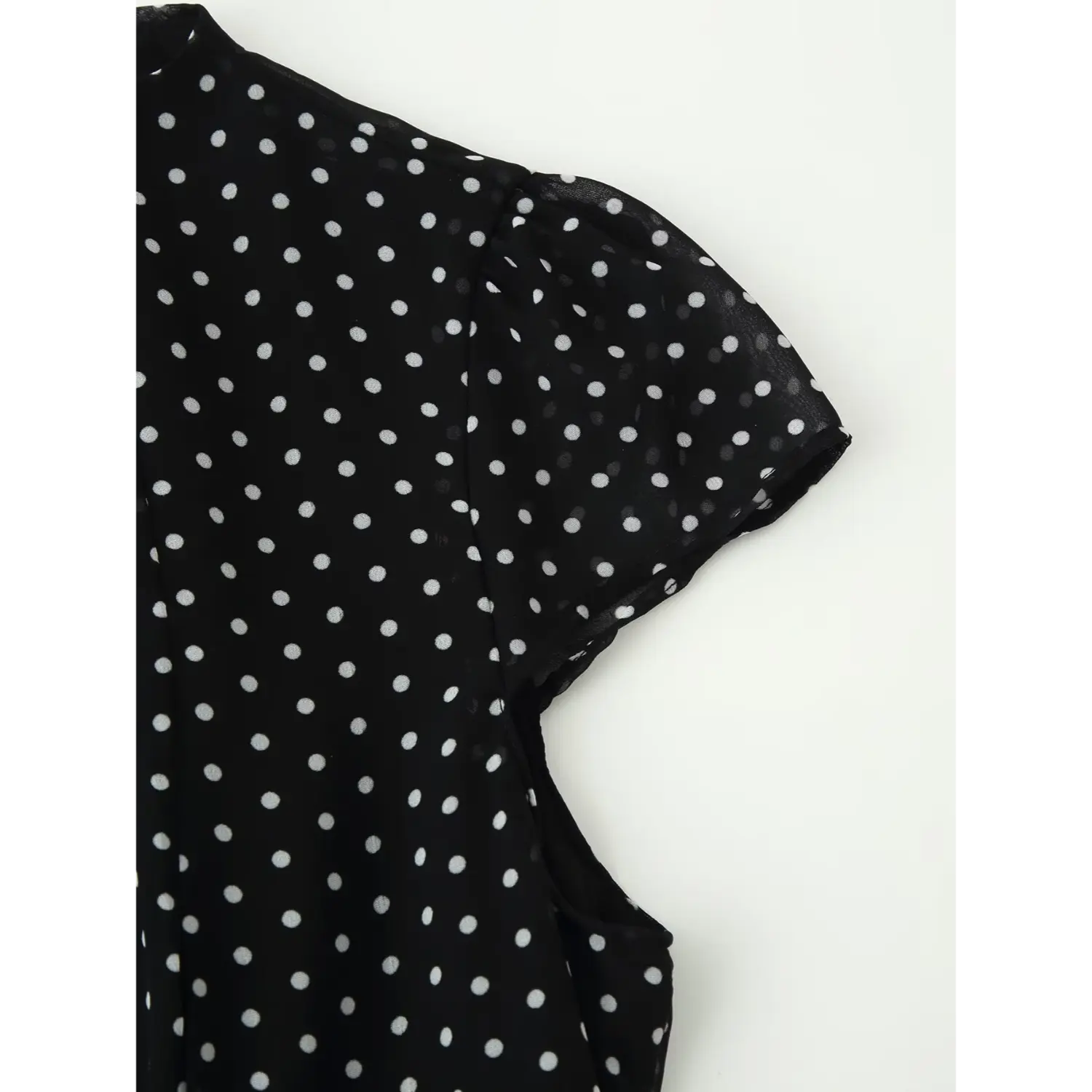 Closeup shot, black chiffon polka dot dress with cap sleeve and shoulder stitching detail