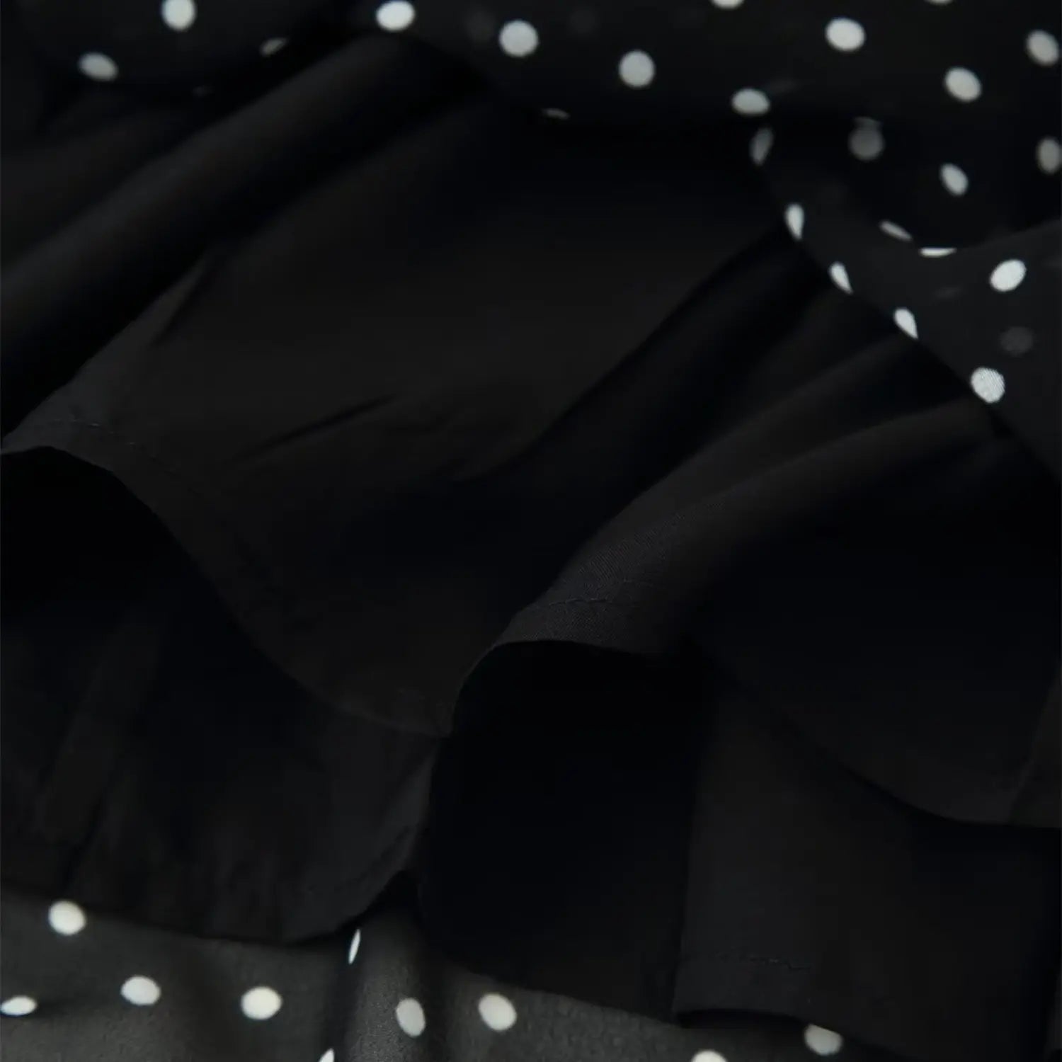 Closeup shot, black chiffon polka dot dress with smooth inner lining fabric detailtexture