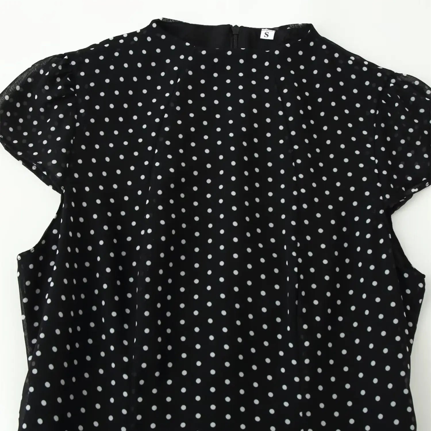 Closeup shot, black chiffon polka dot dress with stand collar and cap sleeve detail