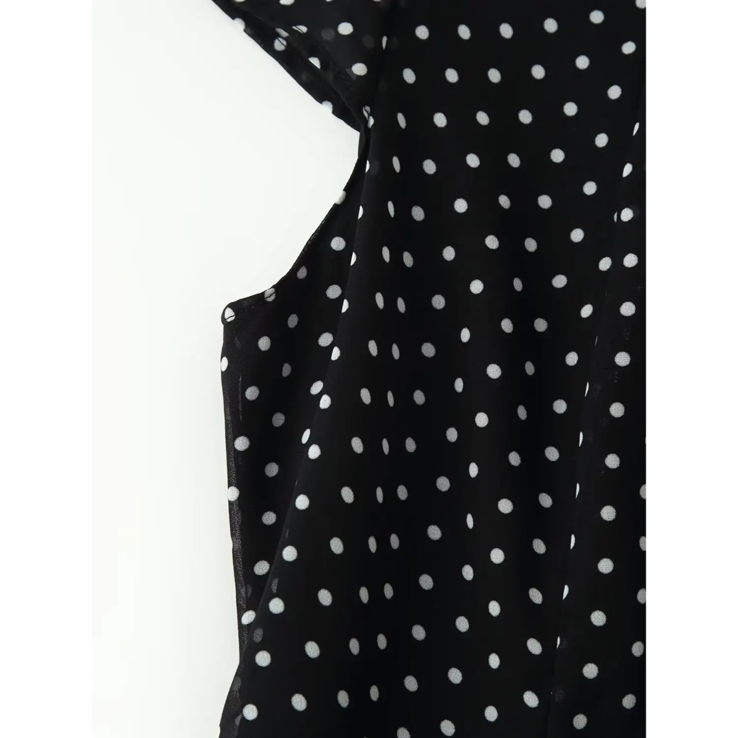Closeup shot, black chiffon polka dot dress with waist dart and side seam detail