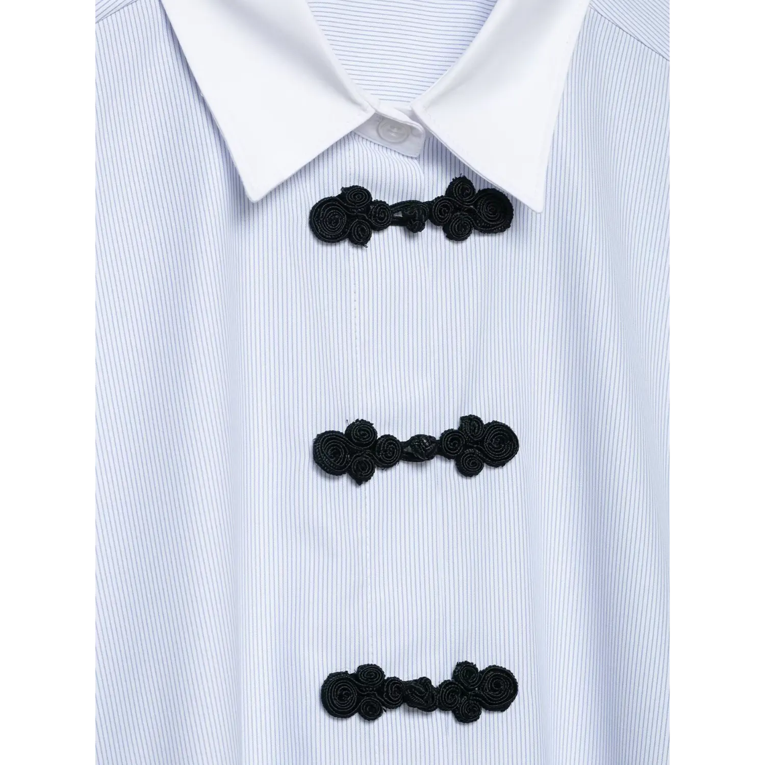 Macro close-up of handmade black chinese frog knot buttons, spiral floral knot detail on striped shirt front placket