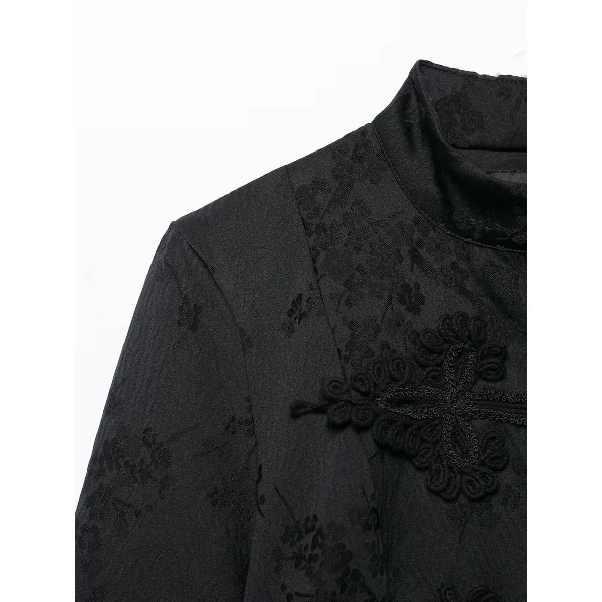 Close‑up of black new chinese jacket shoulder and mandarin collar, floral jacquard fabric, embroidered frog button detail