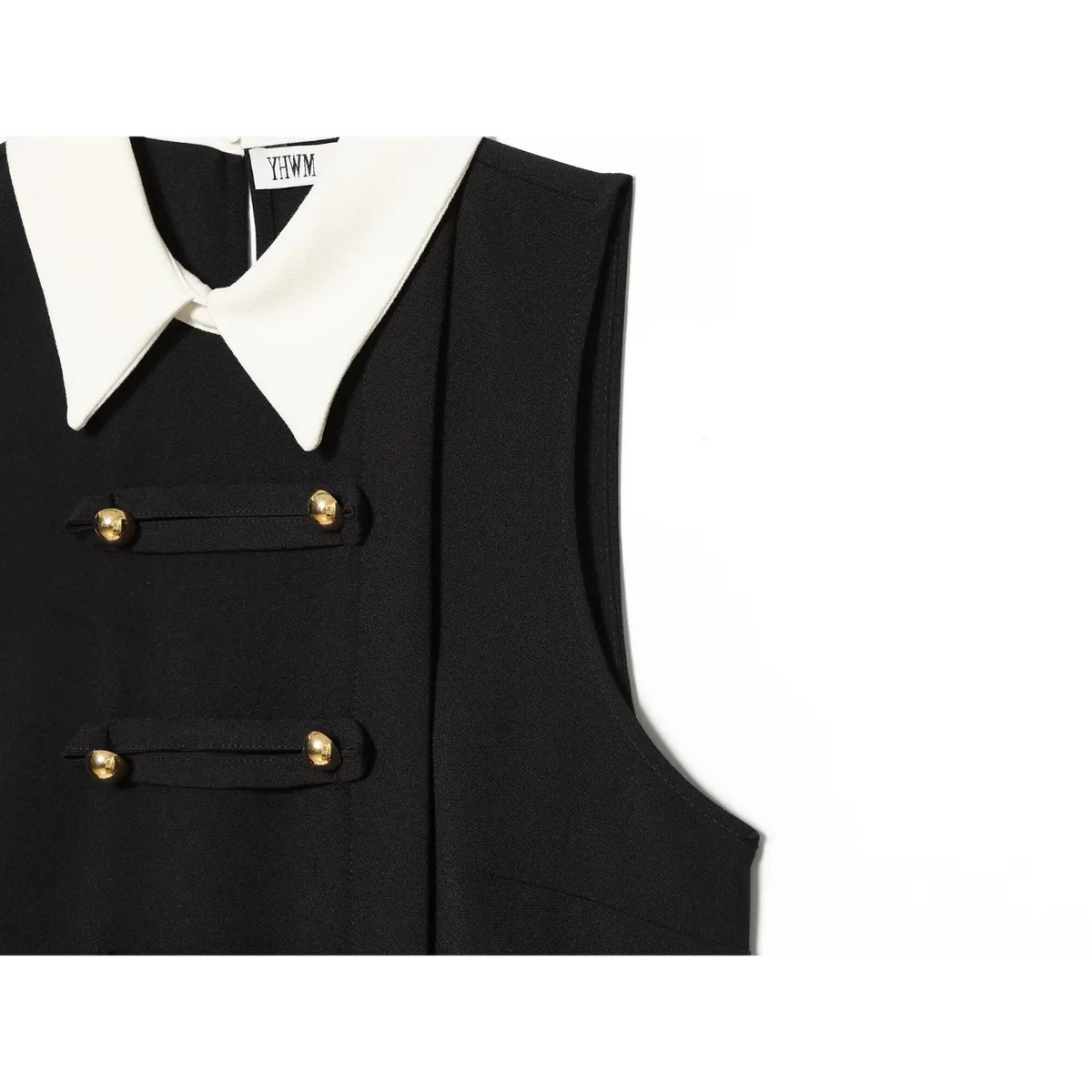 Close-up of side seam, armhole and gold button tab