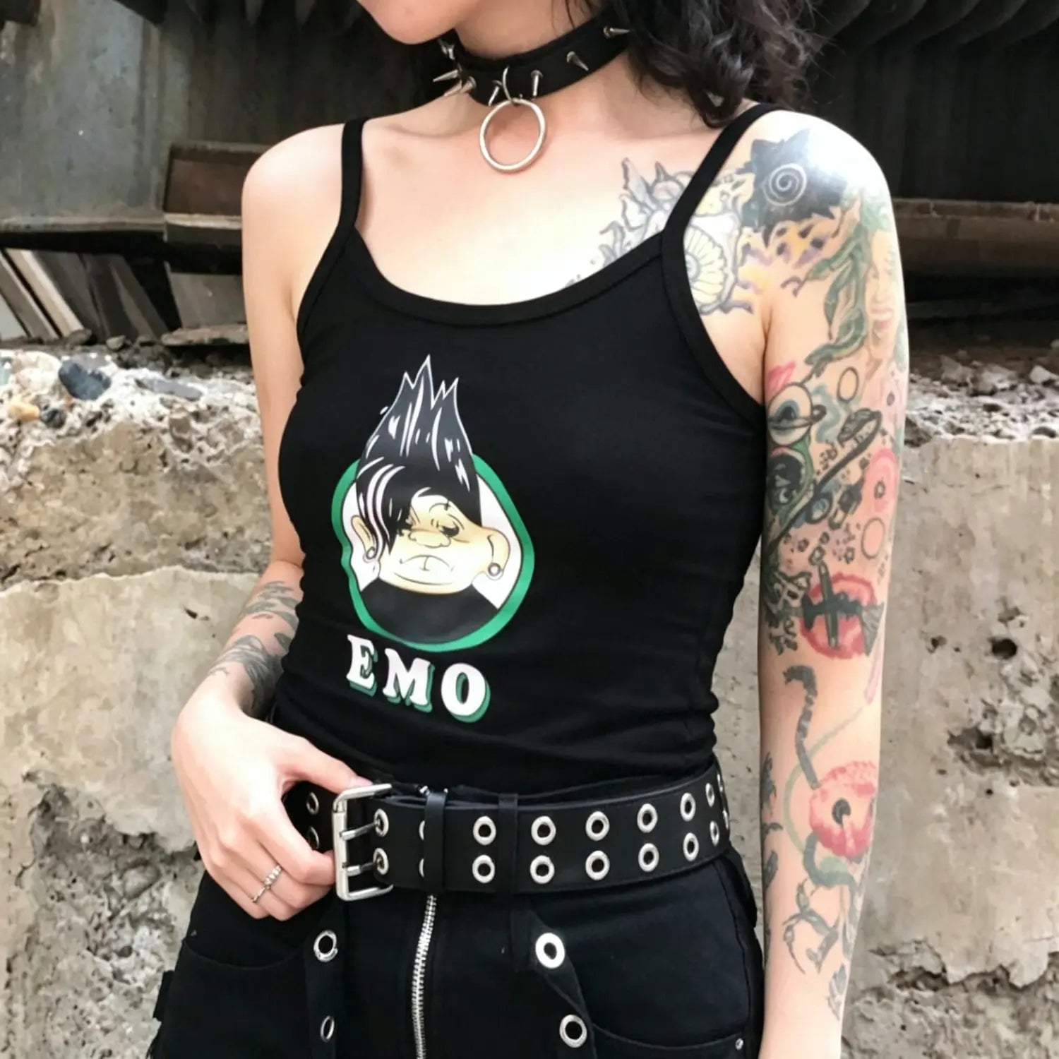 Model wearing black slim spaghetti strap crop cami tank top with cartoon graphic print