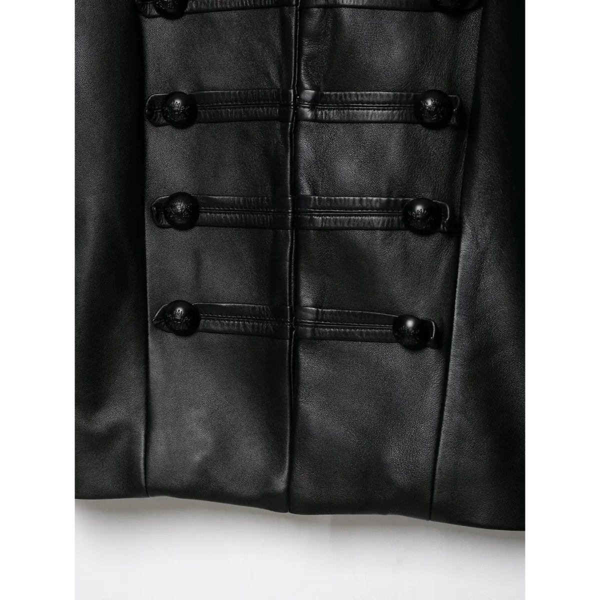 Lower front detail shot of black cropped leather jacket, showing embossed decorative buttons and stitching