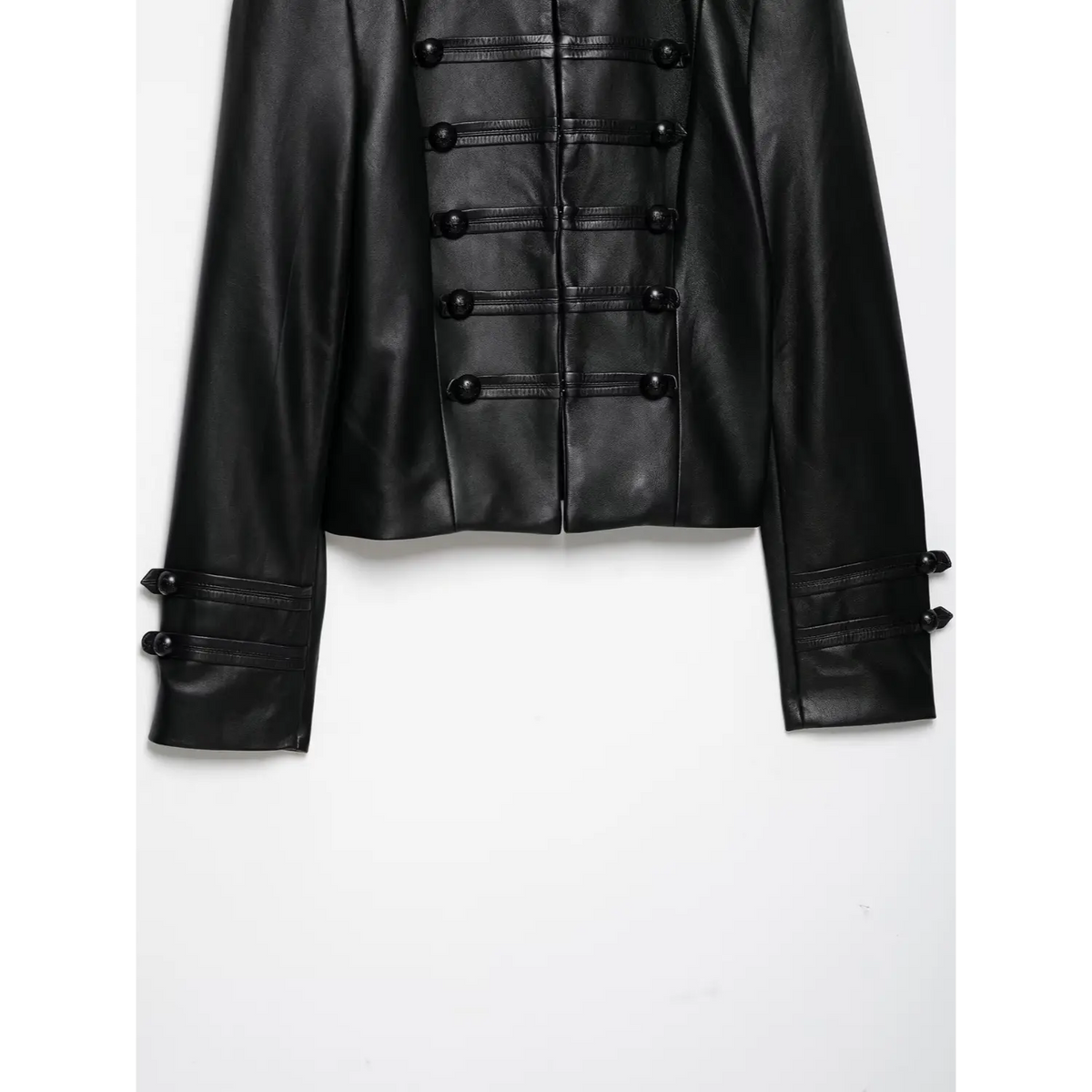 Lower front view of black cropped leather jacket, showing button details and long sleeves