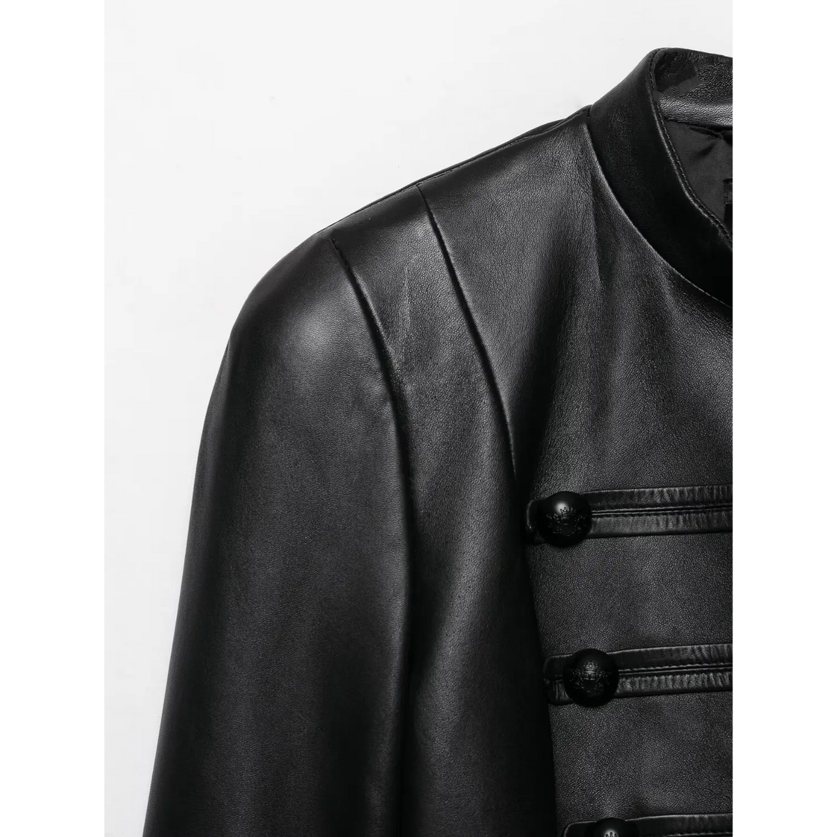 Close-up of shoulder and front decorative buttons of black faux leather cropped jacket, smooth leather texture