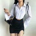 Full body model shot wearing black waist cutout suspender mini skirt paired with white cropped shirt