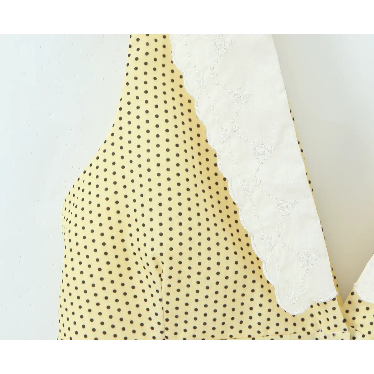 Macro view yellow black polka dot cloth beside lace trim