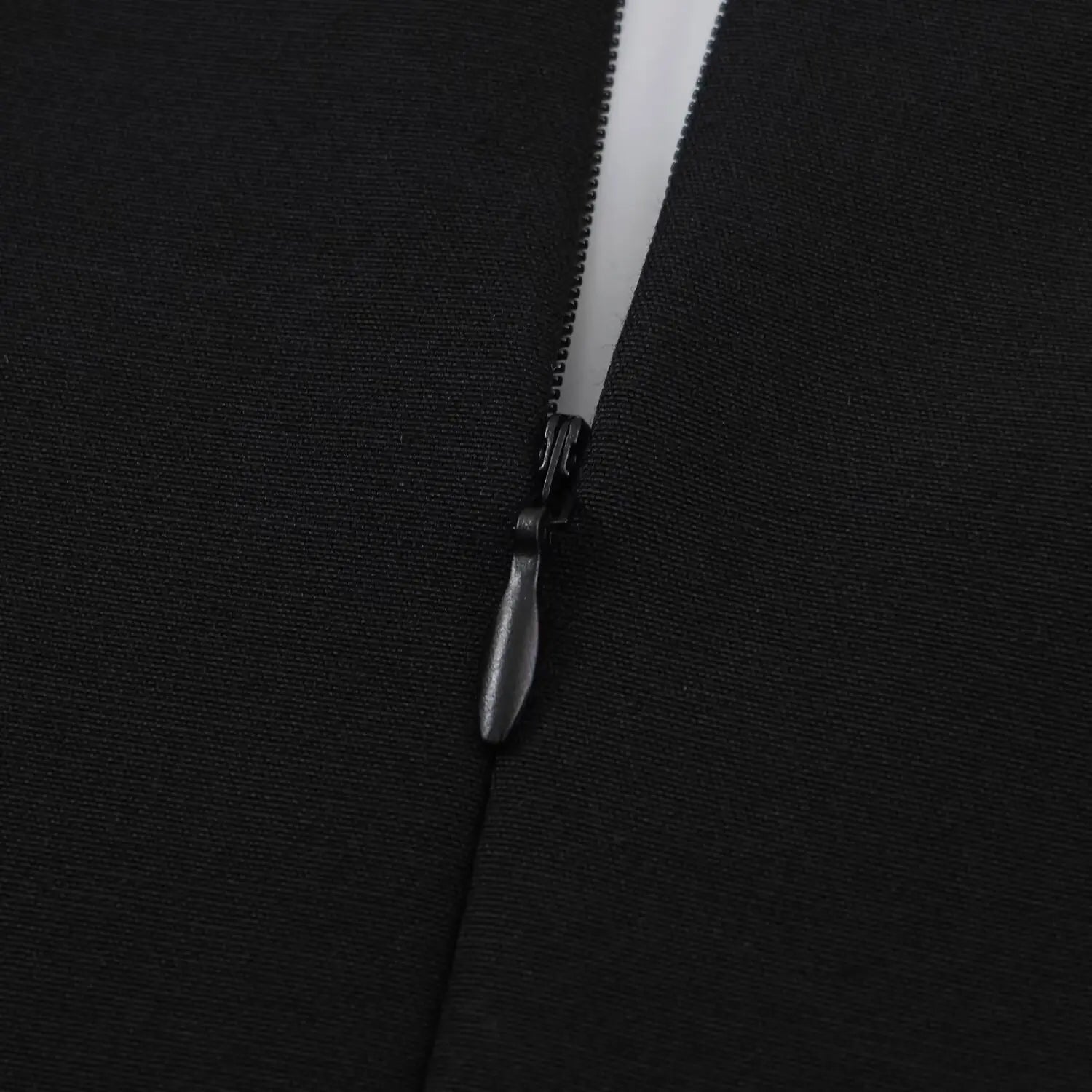 Extreme close-up of invisible zipper pull and teeth on black woven dress